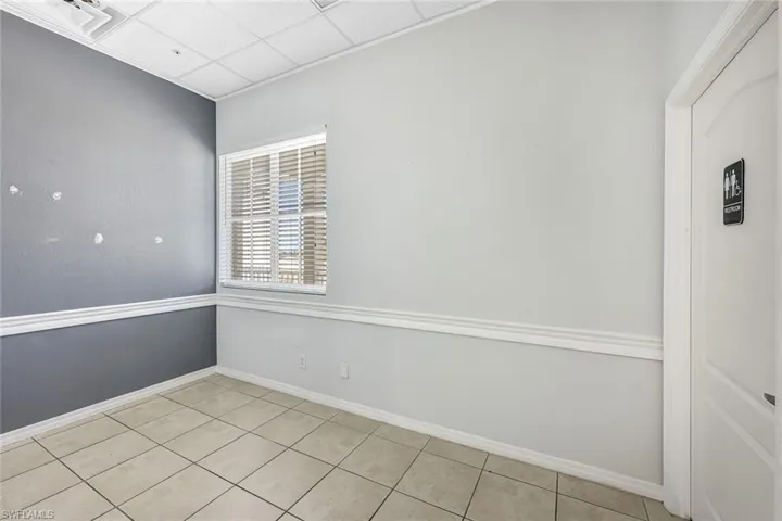 Suite 1 Empty room featuring a drop ceiling and light tile patterned floors