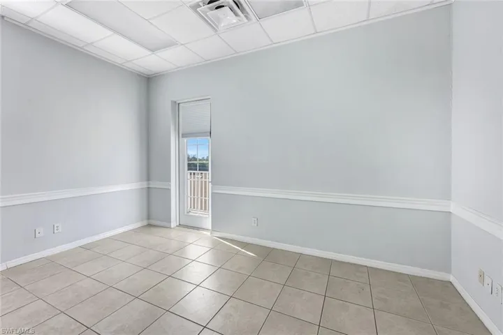Suite 1 Empty room featuring light tile patterned floors and a paneled ceiling