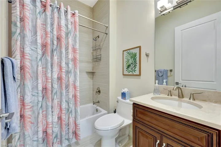 Ensuite guest bathroom featuring shower/tub combo
