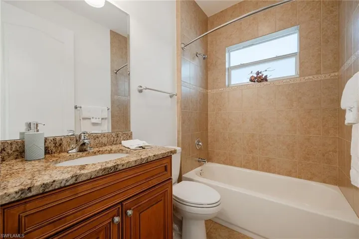 Full bathroom featuring toilet, tiled shower / bath, and vanity
