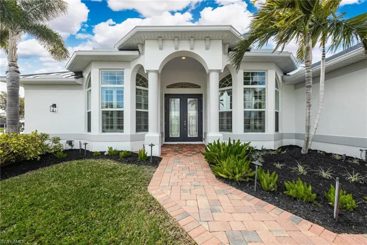 View of exterior entry with french doors and a lawn