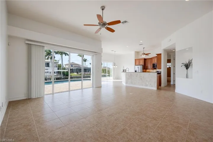Unfurnished living room featuring ceiling fan and light tile patterned flooring