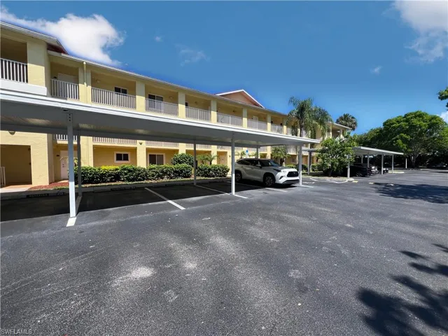 View of parking / parking lot featuring a carport