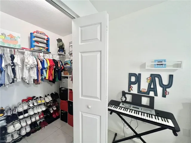 Walk in closet with light tile flooring