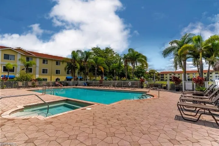 View of swimming pool featuring a community hot tub and a patio area