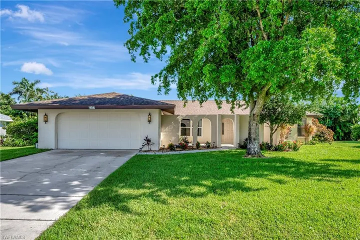 Ranch-style home featuring a garage and a front yard