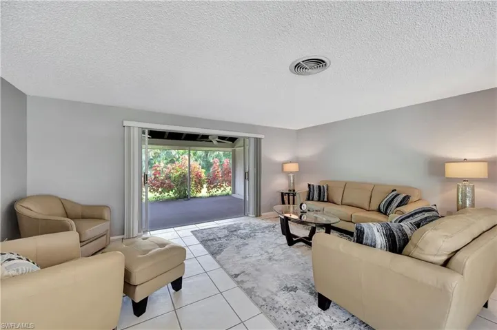 Tiled living room with slider to large lanai