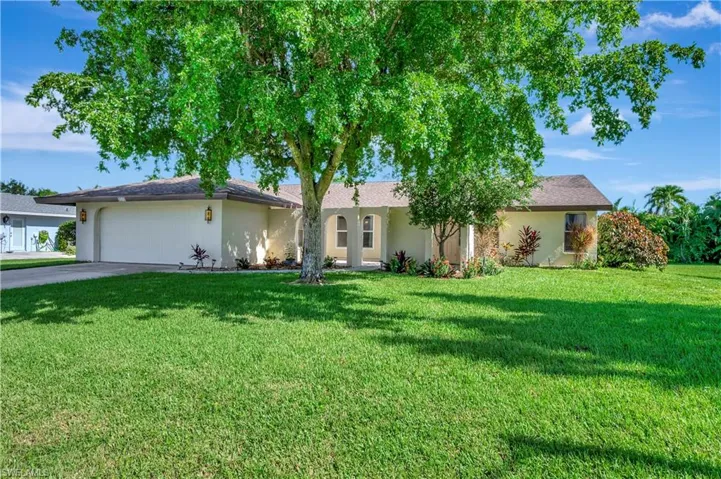 Single story home featuring a garage and a front yard