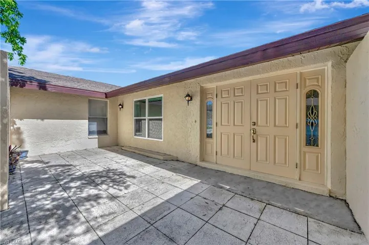 View of exterior entry with a patio area