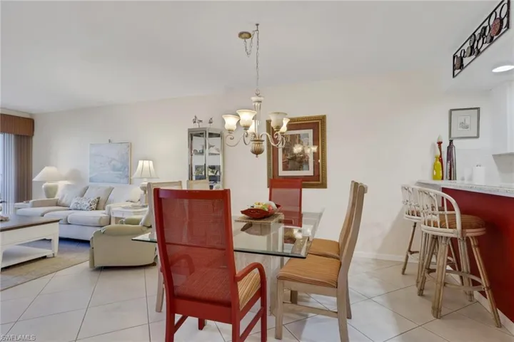 Dining area and breakfast bar featuring light tile patterned floors and suspended lighting
