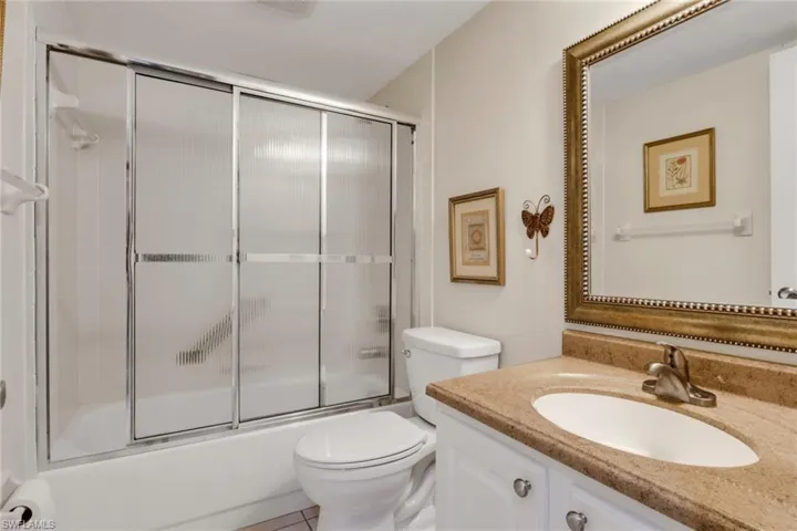 Guest bathroom featuring vanity and shower / bath combination with glass door