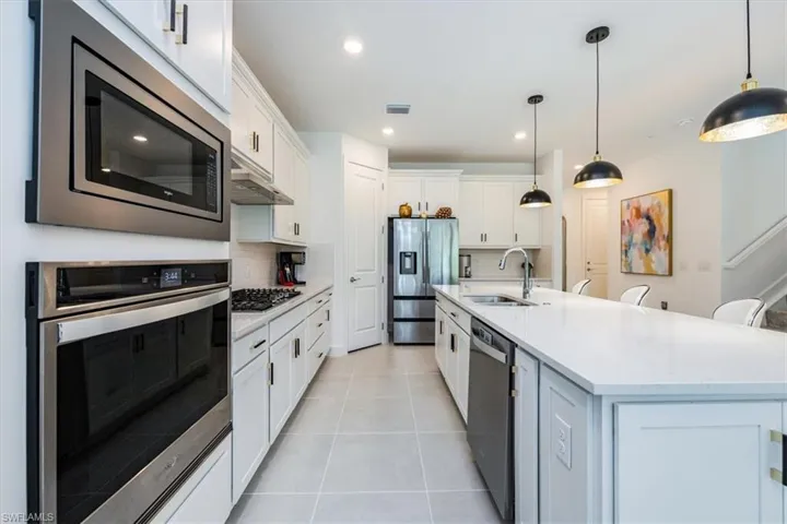 gas cooking and quartz countertops and stainless appliances and huge island