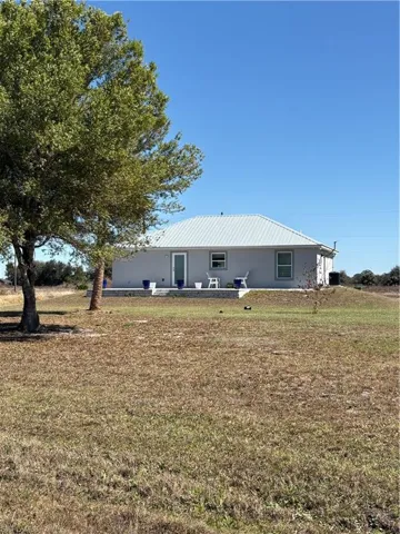 Single-story residence featuring a gray exterior and a corrugated metal roof