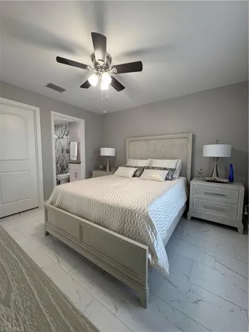 Bedroom featuring light gray walls and white marble-look tile flooring