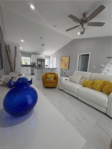 Vaulted ceiling great room featuring recessed lighting and a ceiling fan