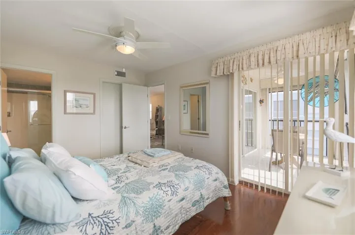 Bedroom featuring hardwood / wood-style flooring, multiple windows, and ceiling fan