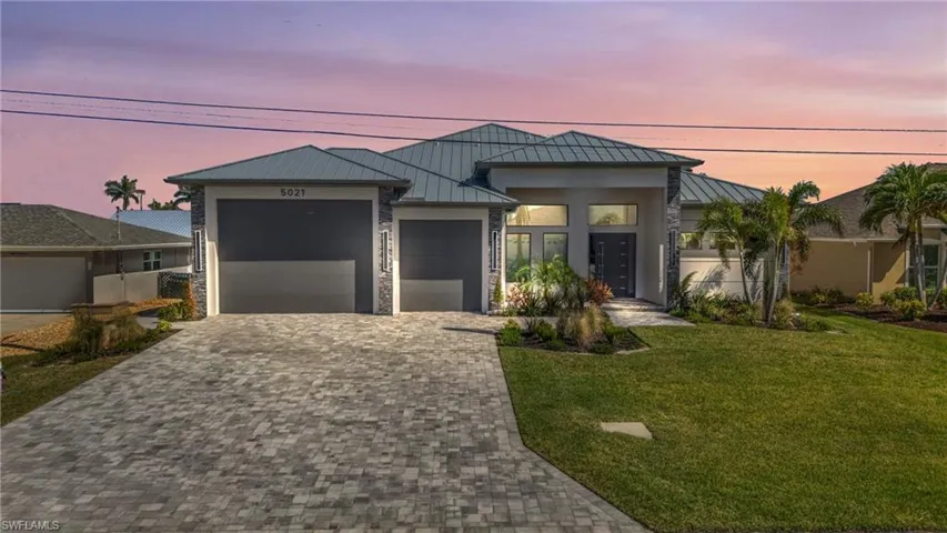View of front of house featuring a garage and a lawn