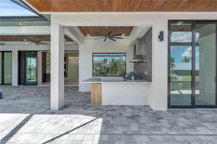 View of patio featuring ceiling fan, grilling area, and an outdoor bar