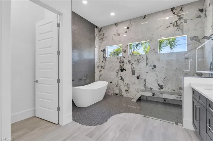 Bathroom featuring vanity and independent shower and bath