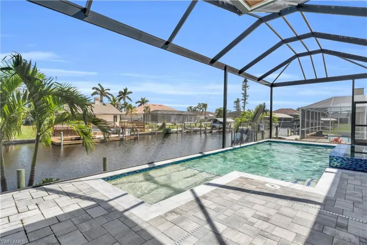 View of swimming pool featuring a water view, a patio area, and a lanai