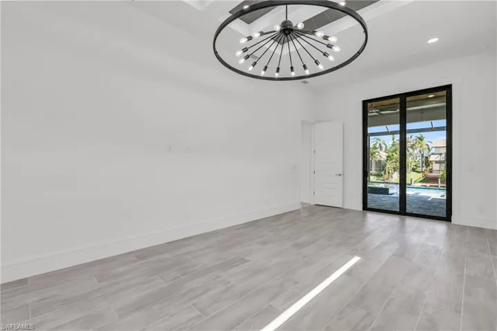 Empty room with an inviting chandelier and light hardwood / wood-style flooring