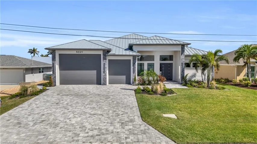 View of front of home featuring a front yard and a garage