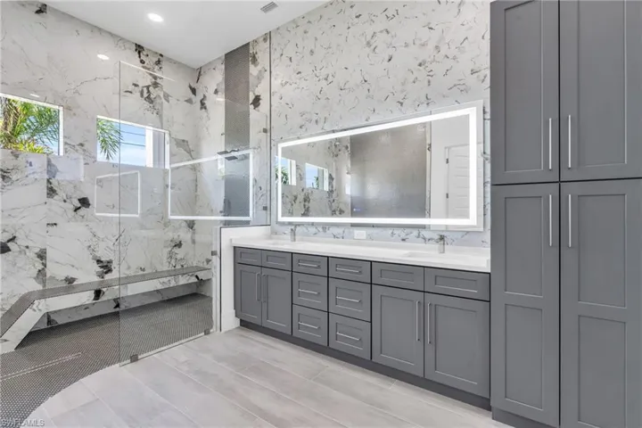 Bathroom with vanity, tile walls, and an enclosed shower