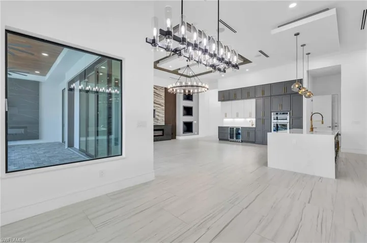 Unfurnished living room featuring a large fireplace and sink