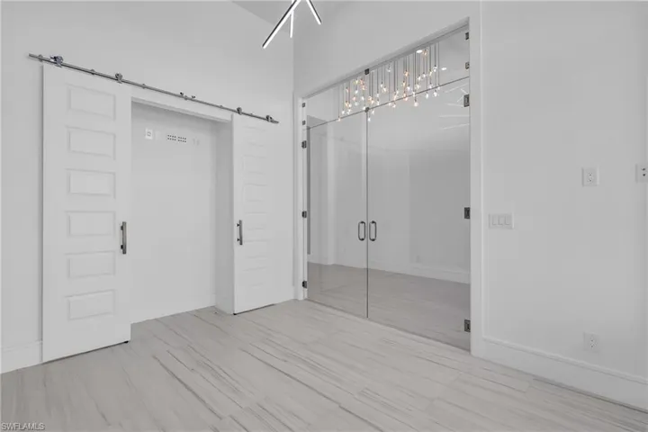 Unfurnished bedroom featuring a barn door and a closet