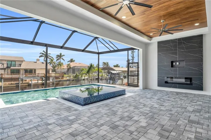 View of swimming pool featuring a lanai, ceiling fan, and a patio area