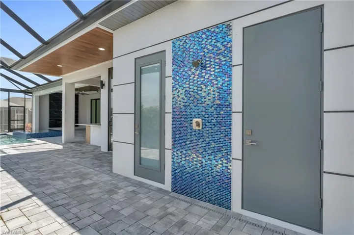View of patio featuring glass enclosure and ceiling fan