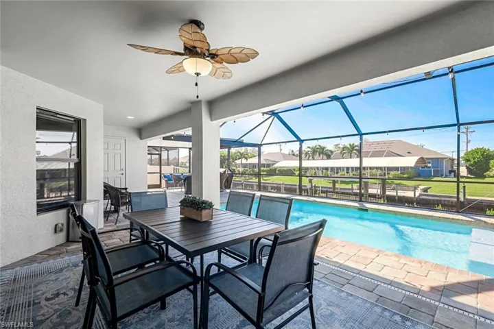 View of pool featuring a lanai, ceiling fan, and a patio