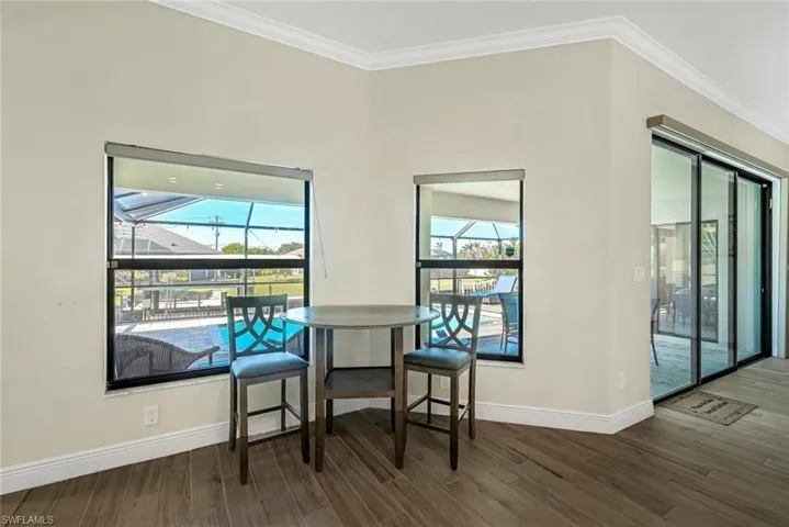 Dining room featuring a wealth of natural light, dark hardwood / wood-style flooring, and crown molding