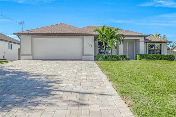 View of front facade featuring a garage and a front yard