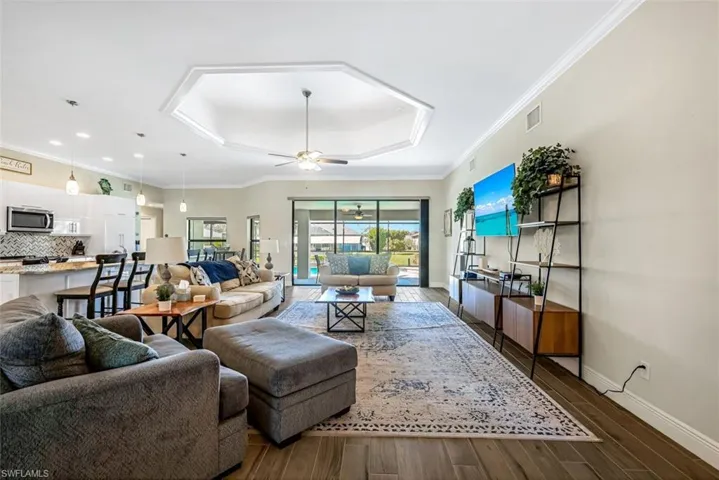 Living room featuring ceiling fan, crown molding, and dark hardwood / wood-style floors