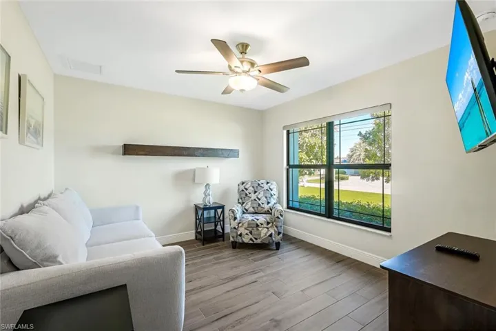Living room with ceiling fan and light hardwood / wood-style flooring