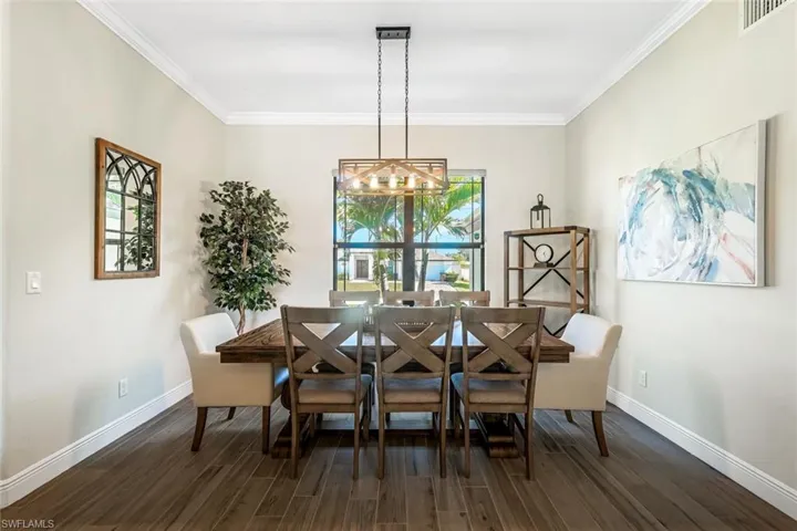 Dining space featuring dark hardwood / wood-style flooring and ornamental molding