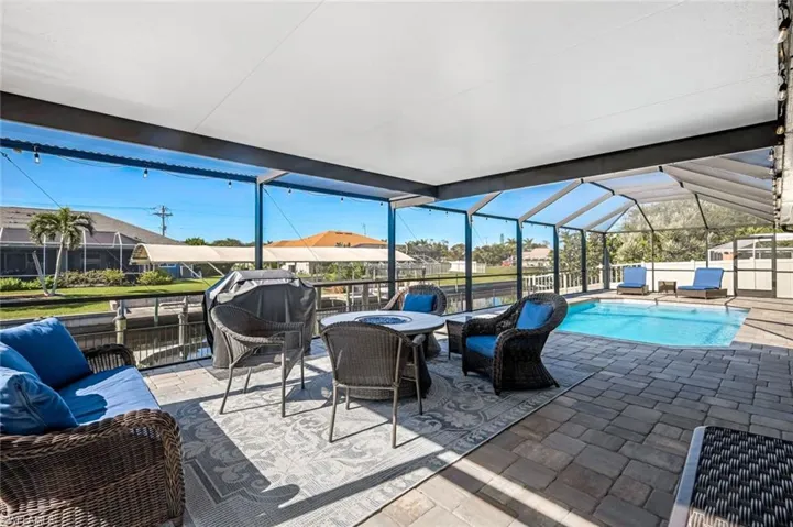 View of patio with a lanai, an outdoor living space, a grill, and a fenced in pool