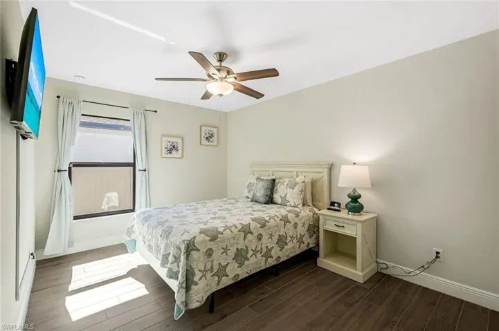 Bedroom featuring ceiling fan and dark hardwood / wood-style flooring