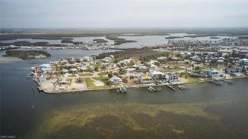 Aerial view of property and surrounding area with a large body of water and nearby suburban area