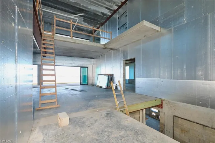 Misc room featuring concrete flooring and a towering ceiling