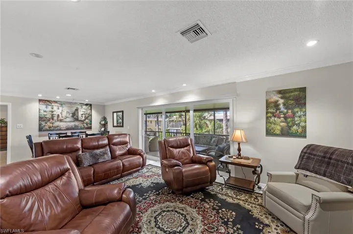 Living area with recessed lighting, crown molding, and a textured ceiling