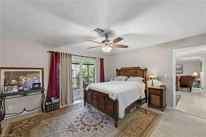 Bedroom featuring access to outside, ceiling fan, and a textured ceiling