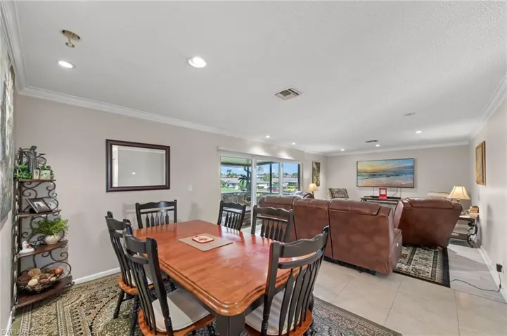 Dining space featuring crown molding, recessed lighting, and light tile patterned flooring
