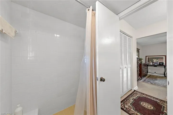 Bathroom featuring a shower stall, a closet, and a textured ceiling