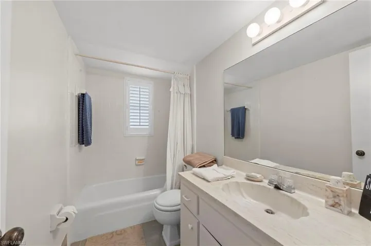 Guest Bathroom with vanity, shower / bath combo, and light tile patterned floors