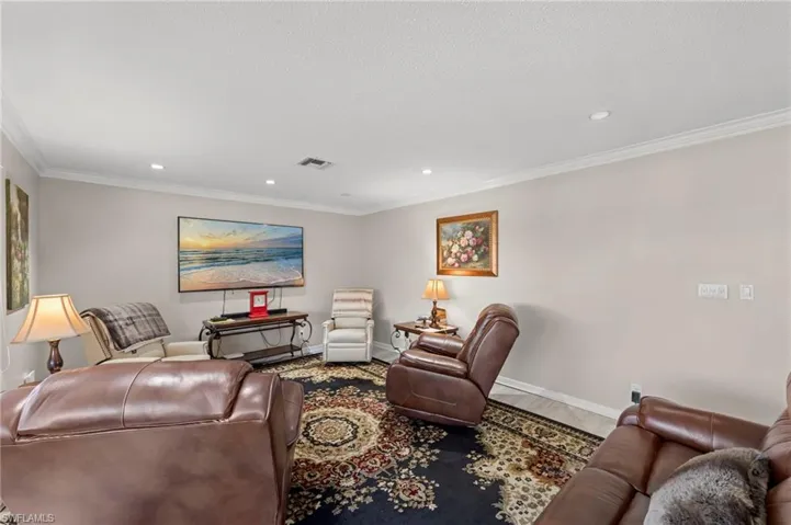 Living area featuring ornamental molding, recessed lighting, and wood finished floors