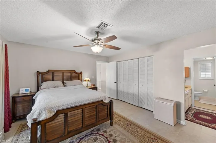 Bedroom featuring a ceiling fan, a textured ceiling, and a closet