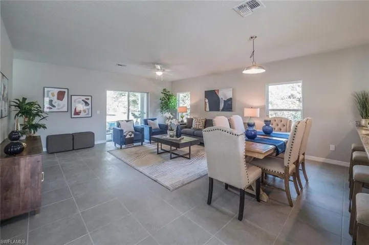 Tiled dining area with ceiling fan and baseboards