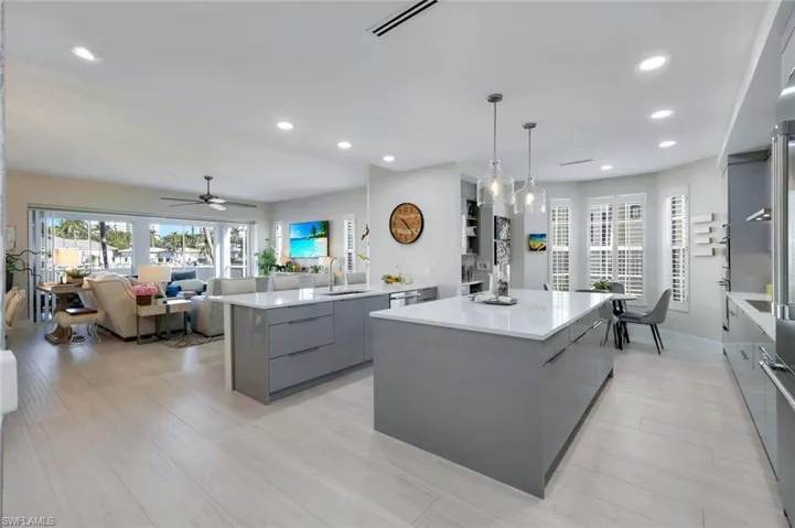 Kitchen with gray cabinets, modern cabinets, a kitchen island, decorative light fixtures, and ceiling fan